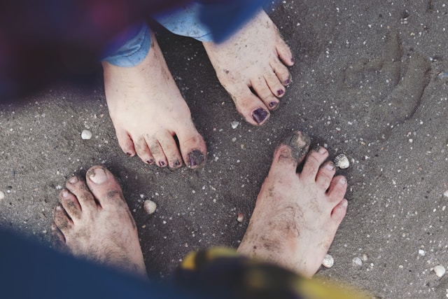 две пары босых ног в песке