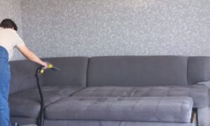 Женщина чистит старый диван