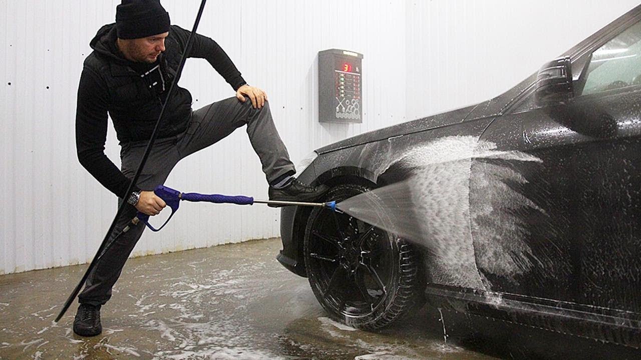 Мужчина моет автомобиль