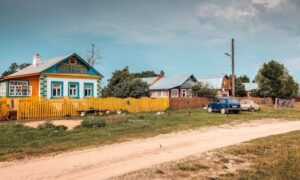 желтый деревенский дом на проселочной дороге