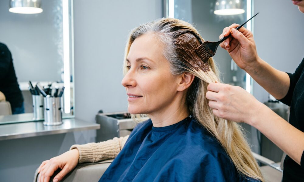 Женщина в саолне красоты закрашивает седину