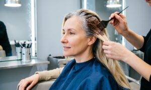 Женщина в саолне красоты закрашивает седину