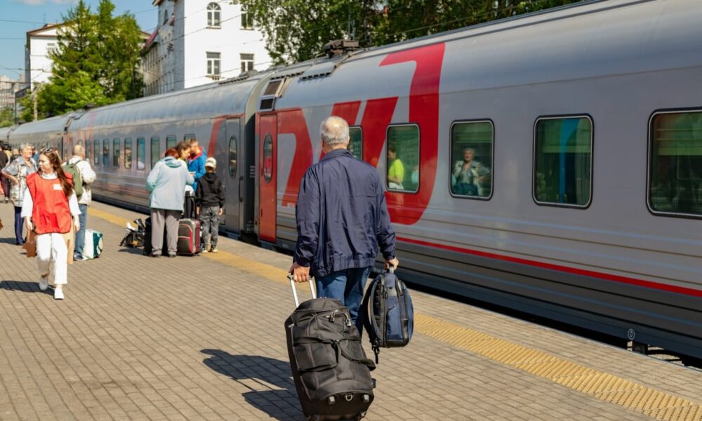 Пассажиры поезда идут к своим вагонам