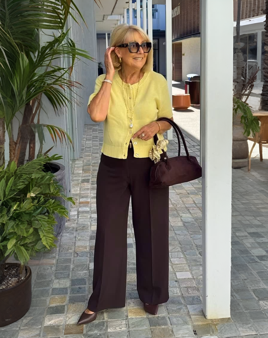 Женщина в жёлтой блузе и коричневых брюках