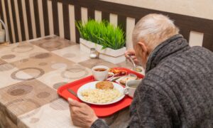 Пожилой мужчина ест