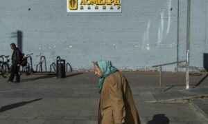 Женщина пенсионного возраста на фоне вывески ломбарда.
