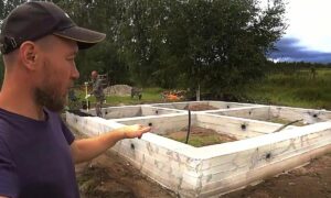 Рабочий объясняет, как правильно заделывать трещины в фундаменте дома.