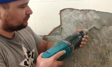 Мужчина снимает плитку в ванной