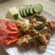 Скрембл с колбасой и овощами на тарелке.