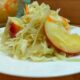 квашенная капуста с яблоками на тарелке.